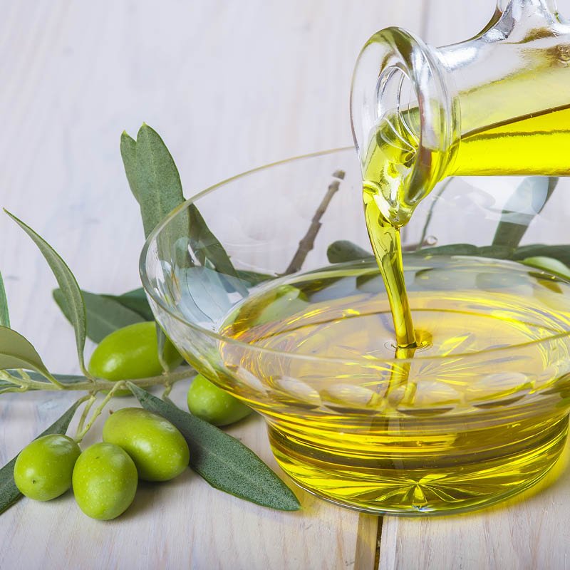 Olivenöl, was in eine Glasschüssel gekippt wird