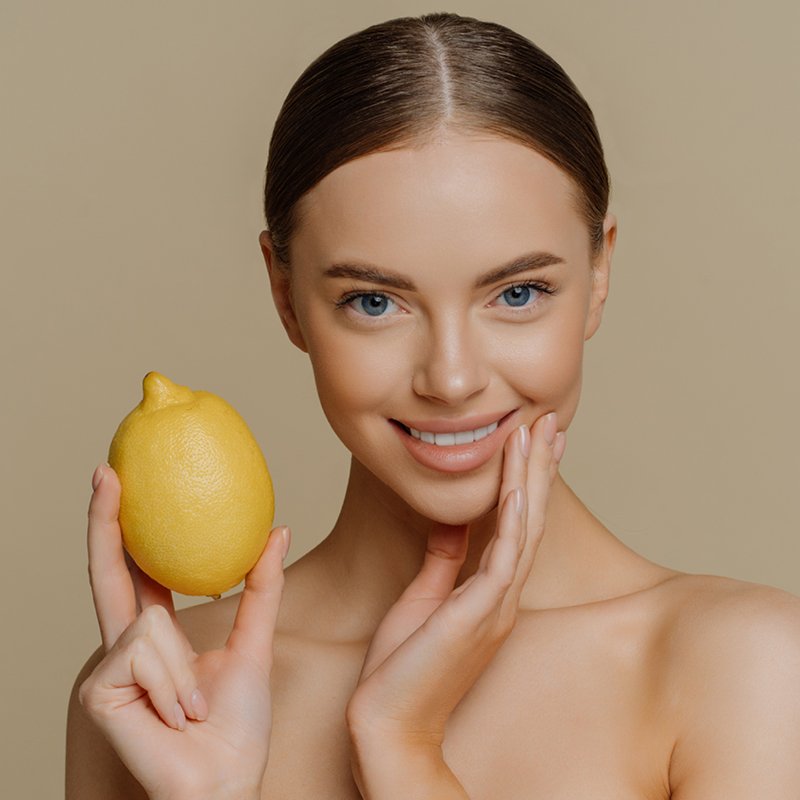 Frau, die eine Zitrone in der Hand hält