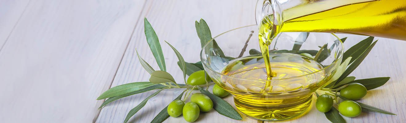 Olivenöl, was in eine Glasschüssel gekippt wird